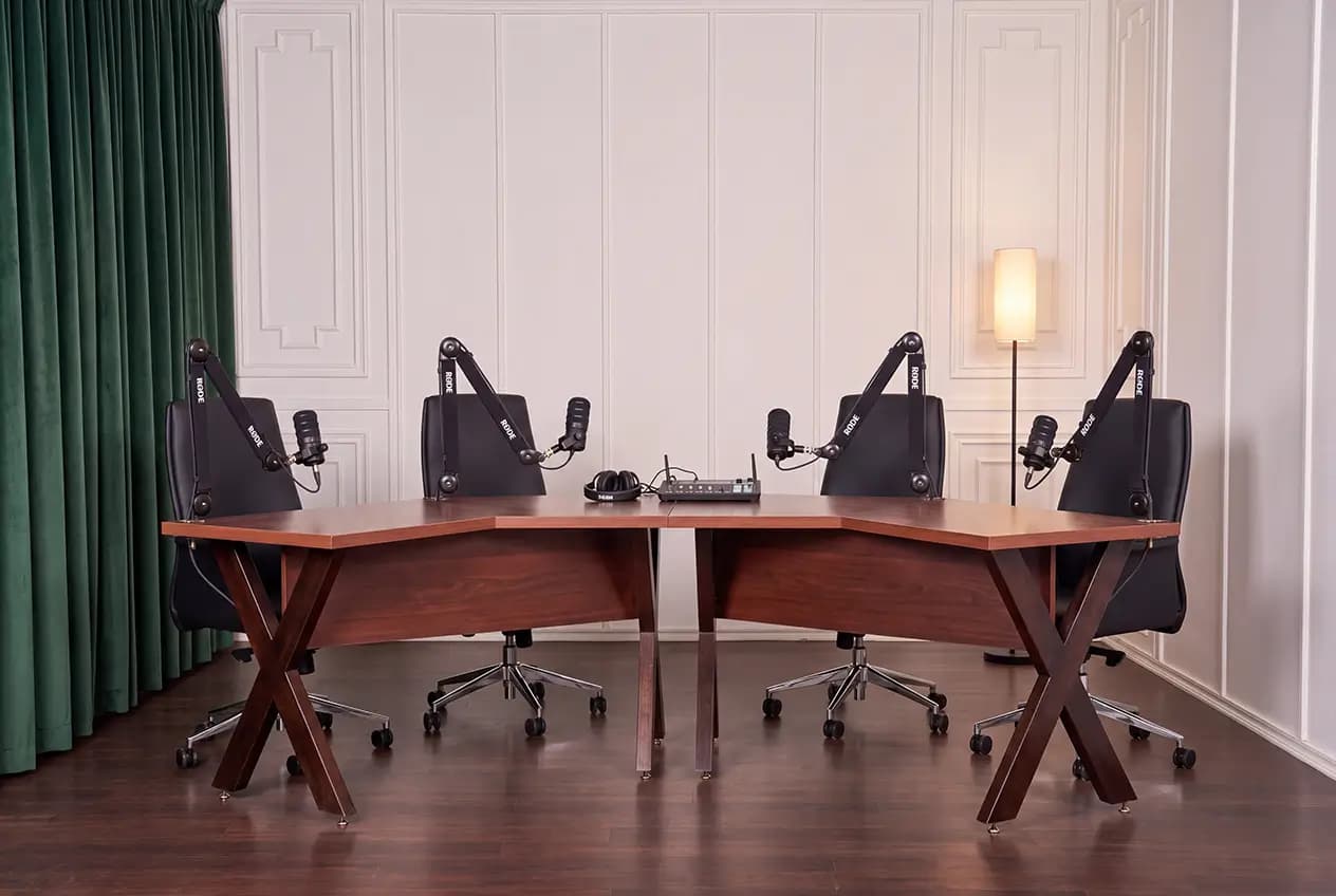 A four-seat podcast table with microphones on boom arms